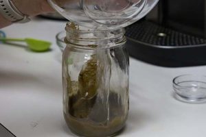 Adding hot water to kratom and lemon juice mixture