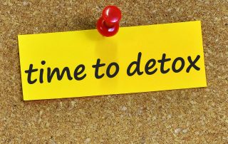 Featured image depicting a yellow scrap of paper pinned to a cork board backing. The scrap of paper reads "Time to Detox"