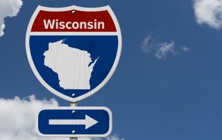 Featured Image depicting a highway sign for the state of Wisconsin, with an arrow pointing onward.